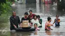 Warga melintasi banjir dibantu ban karet di perumahan Pondok Hijau Permai, Bekasi, Senin (20/2). Terdata, sedikitnya ada empat perumahan yang terendam banjir hingga ketinggian satu meter lebih. (Liputan6.com/Gempur M. Surya)