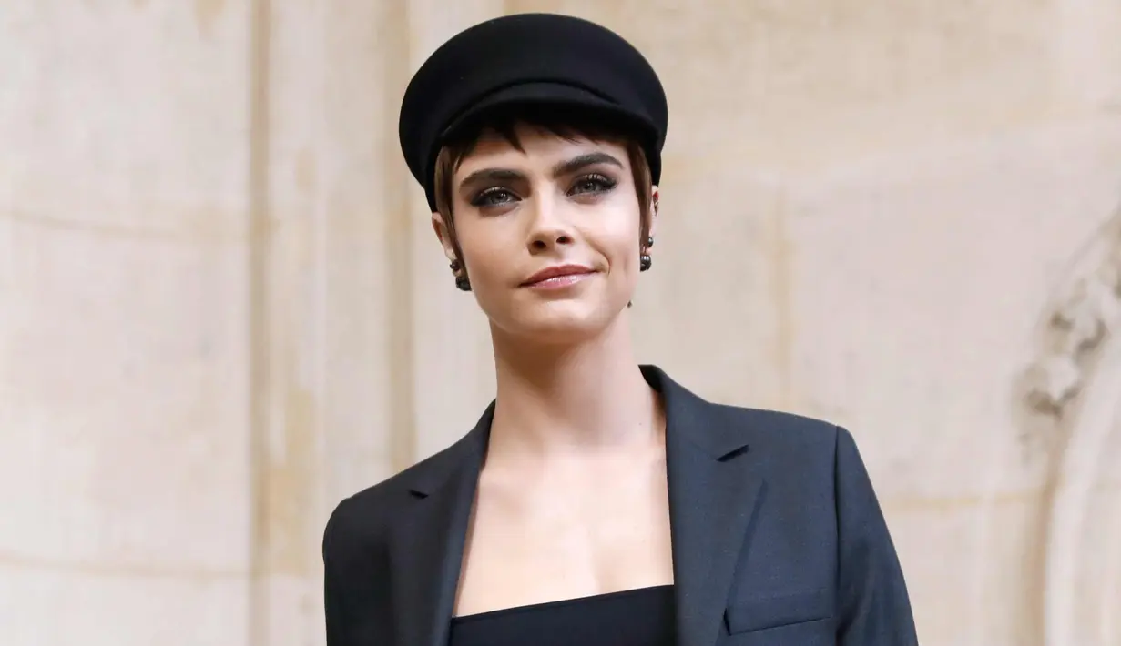 Aktris dan model Inggris Cara Delevingne berpose saat pemotretan sebelum tampil memperagakan busana koleksi fall/winter 2018 Christian Dior di Paris Fashion Week, Prancis (27/2). (AFP Photo/Patrick Kovarik)