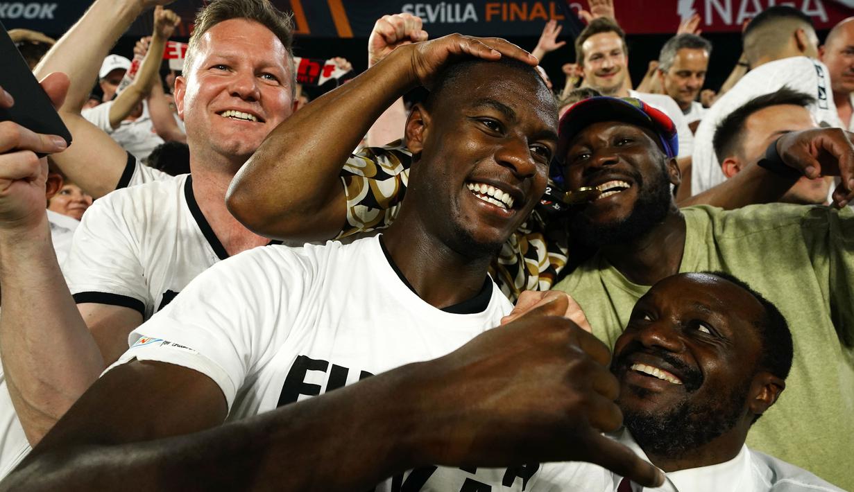 Pemain Eintracht Frankfurt, Evan N'Dicka merayakan kemenangan bersama fans setelah memenangkan pertandingan final sepak bola Liga Europa antara Eintracht Frankfurt dan Rangers FC di stadion Ramon Sanchez Pizjuan, Sevilla, Spanyol, Kamis, 19 Mei 2022. Frankfurt mengalahkan Rangers 5-4 dalam babak adu penalti adu penalti setelah pertandingan berakhir imbang 1-1. (AP/Manu Fernandez)