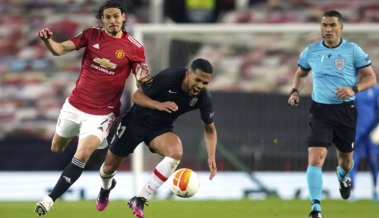 Penyerang Manchester United, Edinson Cavani berebut bola dengan gelandang  Granada, Yangel Herrera dalam leg kedua perempat final Liga Europa di Stadion Old Trafford, Jumat dinihari WIB (16/4/2021). MU menunjukkan dominasinya atas Granada usai mencatat kemenangan 2-0. (AP Photo/Dave Thompson)