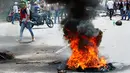 Seorang demonstran berjalan di dekat ban yang dibakar saat aksi unjuk rasa anti-Presiden Nicolas Maduro di San Cristobal, Venezuela, (26/10). Sekitar 120 orang terluka dan 147 demonstran lainnya ditangkap polisi. (REUTERS/Carlos Eduardo Ramirez)