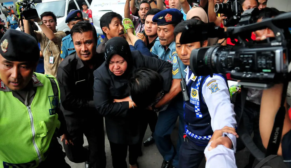 Walikota Surabaya Tri Rismaharini saat memapah salah satu keluarga penumpang AirAsia QZ8501 ke ruang kesehatan, Jatim, Selasa (30/12/2014). (Liputan6.com/Johan Tallo)