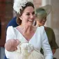 Kate Middleton menggendong Pangeran Louis tiba pada acara pembaptisan di Chapel Royal, St. James Palace, London, Senin (9/7). Kate tampil berbalut gaun putih dengan bahu sedikit terbuka keluaran rumah mode Alexander McQueen. (Dominic Lipinski/POOL/AFP)