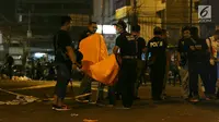 Polisi dan Puslabfor mengevakuasi potongan jenazah ketika  olah TKP ledakan di Terminal Kampung Melayu, Rabu (24/5). Jarak warga semakin menjauh di radius sekitar 150 meter lebih dari TKP. (Liputan6.com/Angga Yuniar)