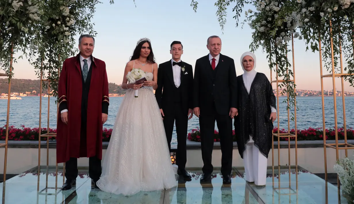 Presiden Turki Recep Tayyip Erdogan (kedua kanan) menghadiri pernikahan gelandang Arsenal asal Jerman, Mesut Ozil dan Amine Gulse di sebuah hotel mewah di Istanbul, Jumat (7/6/2019). Presiden Erdogan mendapat peran istimewa dengan menjadi pendamping Ozil. (TURKISH PRESIDENTIAL PRESS SERVICE/AFP)