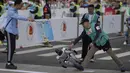 Sebuah robot humanoid kehilangan keseimbangan saat melewati garis finis dalam ajang lari half marathon yang berlangsung di Beijing, China, Sabtu (19/04/2025). (AP Photo/Ng Han Guan)