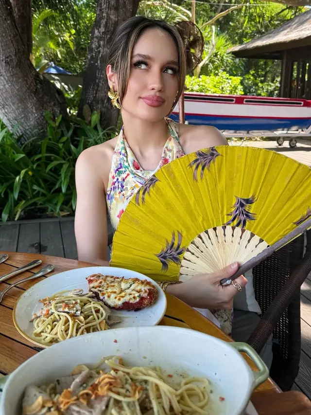 Cinta Laura saat makan bersama Orangtua di Bali dengan membawa kipas. [@claurakiehl]