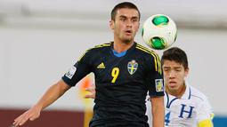 Striker Swedia, Valmir Berisha mengontrol bola di depan bek Honduras, Luis Santos pada laga perempatfinal Piala Dunia U-17 2013 di Khalifa Intrenational Stadium, Al Ain (1/11/2013). Valmir Berisha dinobatkan sebagai top skor Piala Dunia U-17 2013 di Uni Emirat Arab dengan raihan 7 gol. Swedia sendiri finis di posisi ketiga setelah menang 4-1 atas Argentina di laga perebutan tempat ketiga. (AFP/STR)