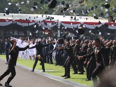 Sejumlah perwira TNI dan Polri melemparkan topi ke udara setelah dilantik Presiden Joko Widodo pada Upacara Prasetya Perwira (Praspa) TNI dan Polri angkatan 2019 di Istana Merdeka, Jakarta, Kamis (16/7/2019). Jokowi melantik 781 perwira TNI dan Polri di Halaman Istana (Liputan6.com/Angga Yuniar)