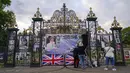 Orang-orang melihat potret Putri Diana yang dipajang di luar gerbang Istana Kensington, di London, Senin, 29 Agustus 2022. Minggu ini, tepatnya pada 31 Agustus, menandai peringatan 25 tahun kematian Putri Diana dalam kecelakaan mobil di Paris. (AP Photo/Alberto Pezzali)