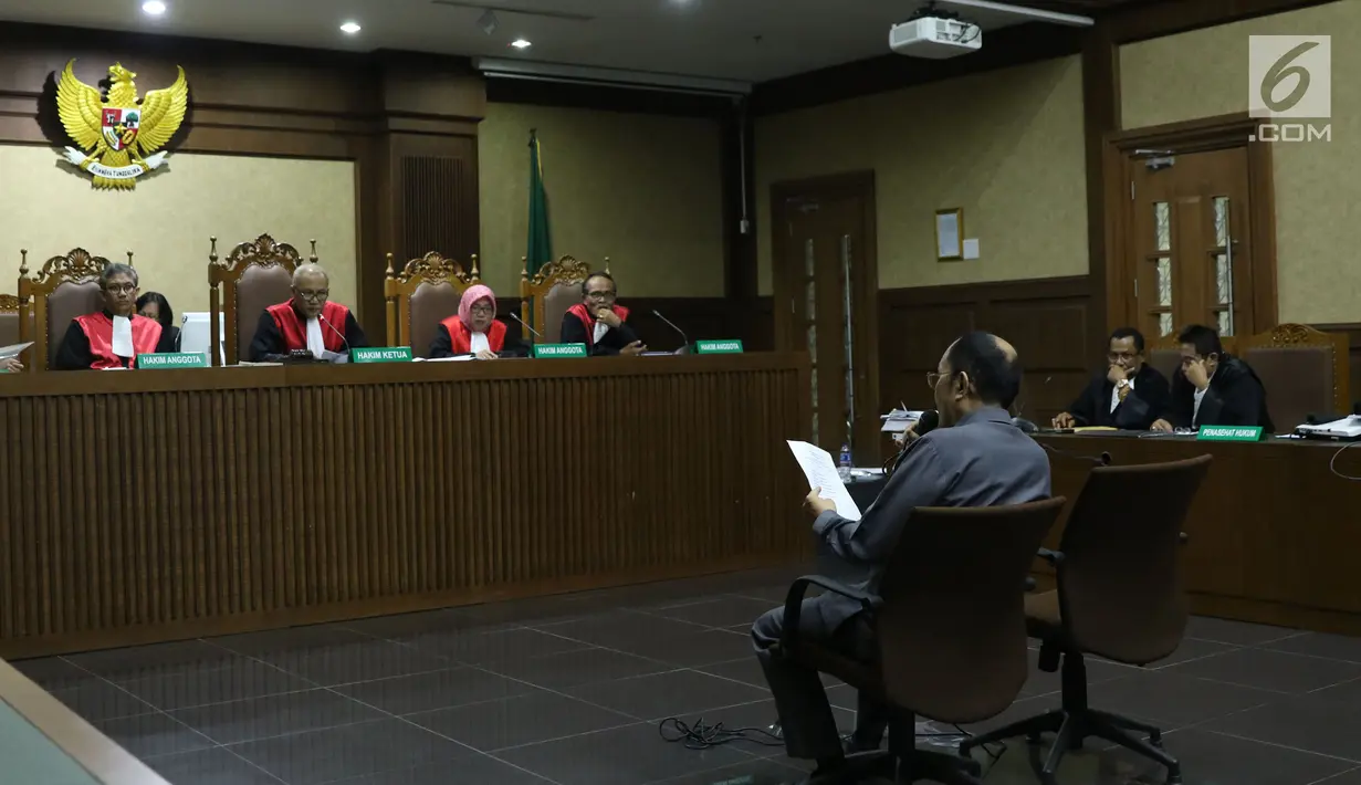 Terdakwa dugaan merintangi penyidikan korupsi e-KTP, Fredrich Yunadi membaca jadwal persidangan yang dikeluarkan majelis hakim saat sidang lanjutan di Pengadilan Tipikor, Jakarta, Senin (30/4). (Liputan6.com/Helmi Fithriansyah)