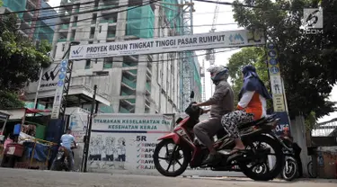 Pengendara sepeda motor melintas di depan proyek Rusun Tingkat Tinggi Pasar Rumput di Jakarta, Selasa (20/3). Aktivitas proyek Rusun Pasar Rumput dihentikan sementara pascainsiden jatuhnya besi pada 18 Maret lalu. (Merdeka.com/Iqbal Nugroho)