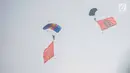 Penerjun payung mengibarkan bendera TNI dan Komando Operasi Khusus (Koopssus) TNI usai peresmian Koopssus TNI di Lapangan Markas Koopssus TNI, Jakarta, Selasa (30/7/2019). Koopssus TNI berasal dari matra darat, laut, dan udara. (Liputan6.com/Faizal Fanani)