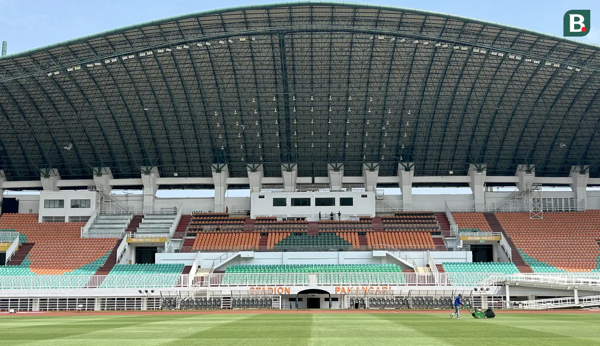 Seorang petugas melakukan perawatan rumput di Stadion Pakansari, Cibinong, Kabupaten Bogor, Rabu (23/7/2026). Selain lapangan, pembenahan atap stadion menjadi salah satu pekerjaan utama menjelang Pakansari menjadi kandang Timnas Indonesia di Piala AFF 2026. Pengerjaan atap telah rampung sesuai target pada 21 Juli 2026 dan kini hanya menyisakan tahap perapihan. (Bola.com/Muhammad Adi Yaksa)