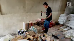 Seorang pria memeriksa barang bukti minuman keras Cap Tikus di Polres Gorontalo, Kamis, (24/1). Sebanyak 1,5 ton Cap Tikus tersebut diselundupkan dari Sulawesi Utara ke Gorontalo menggunakan mobil Avanza. (Liputan6.com/Arfandi Ibrahim)