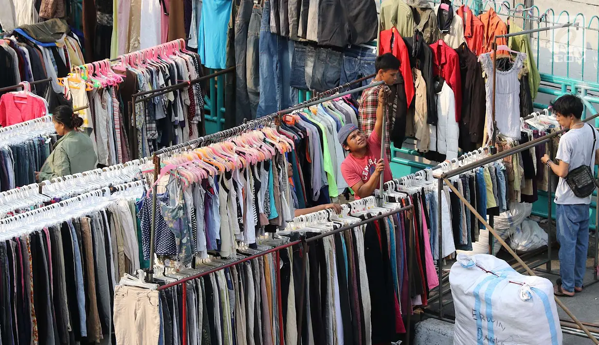 Pedagang pakaian bekas menata dagangannya di sepanjang trotoar kawasan Senen, Jakarta, Jumat (4/5). Sebagian besar pedagang merupakan korban kebakaran beberapa waktu lalu. (Liputan6.com/Immanuel Antonius)