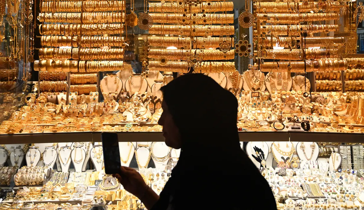 Seorang wanita berjalan melewati toko emas di Spice Bazaar yang bersejarah di distrik Eminonu di Istanbul, Turki (13/7/2019). Spice Bazaar terletak di perempatan Eminönü, distrik Fatih, tempat tersebut merupakan kompleks perbelanjaan paling terkenal setelah Grand Bazaar. (AFP Photo/Ozam Kose)
