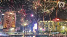 Warga menyaksikan pesta kembang api menyambut tahun baru 2023 di kawasan Bundaran HI, Jakarta, Senin (1/1/2023). Pemprov DKI Jakarta menggelar "car free night" hingga 1 Januari 2023 pukul 02.00 WIB dalam rangka menyambut tahun baru 2023. (Liputan6.com/Angga Yuniar)