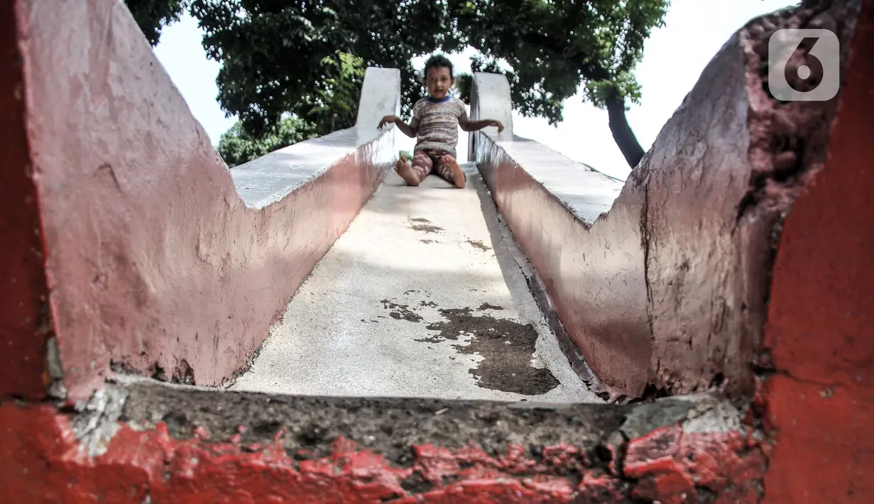 Anak-anak bermain dekat fasilitas yang rusak di Ruang Publik Terpadu Ramah Anak (RPTRA) Manggis, Kelurahan Kemanggisan, Kecamatan Palmerah, Jakarta Barat, Senin (31/10/2022). Minimnya pengawasan oleh pihak terkait menyebabkan kondisi sejumlah wahana bermain di RPTRA Manggis yang dibangun era Gubernur DKI Jakarta Basuki Tjahaja Purnama alias Ahok itu kini dalam kondisi rusak dan tak terawat. (merdeka.com/Iqbal S. Nugroho)
