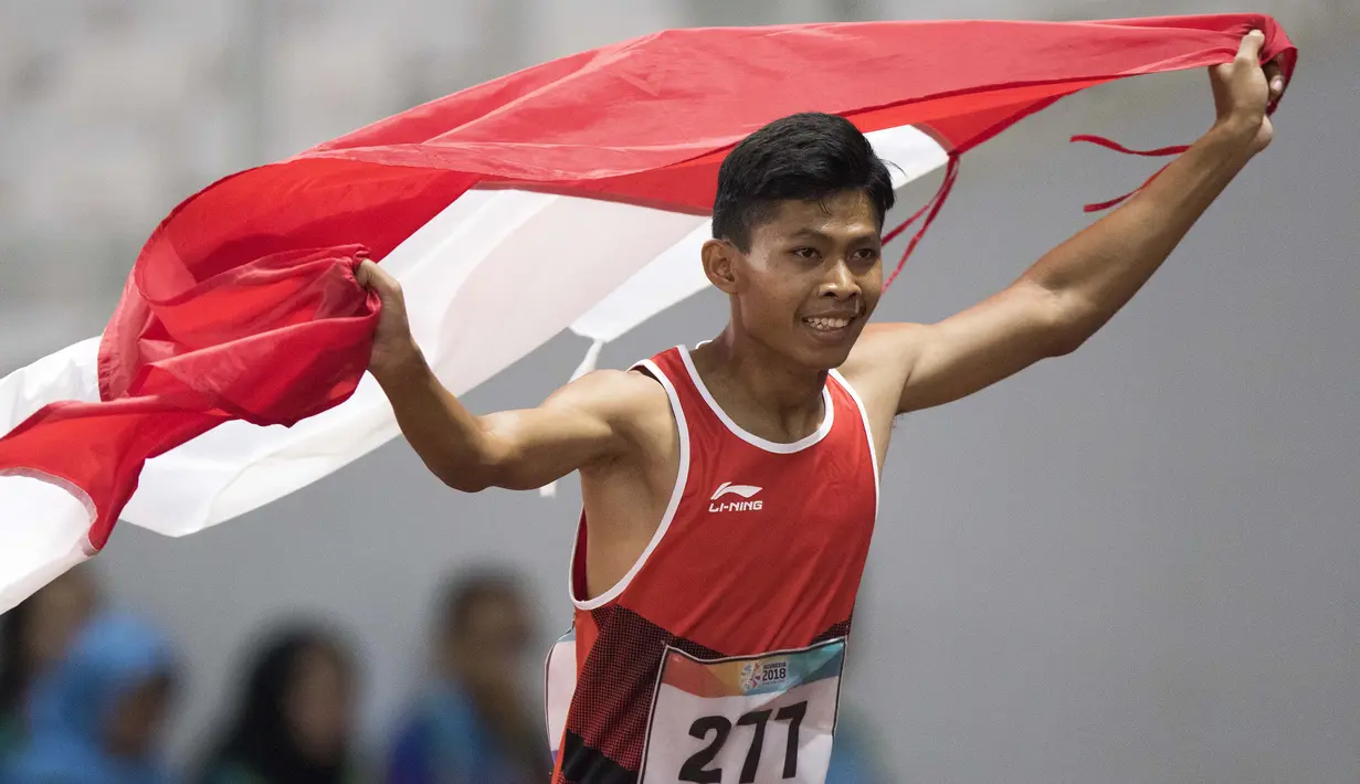 Purnomo Sapto Yogo pelari Indonesia meraih medali emas di nomor 100 meter putra klasifikasi T37 pada Asian Para Games 2018, di Stadion Utama Gelora Bung Karno Jakarta, Selasa (9/10/2018).  (Bola.com/Peksi Cahyo)