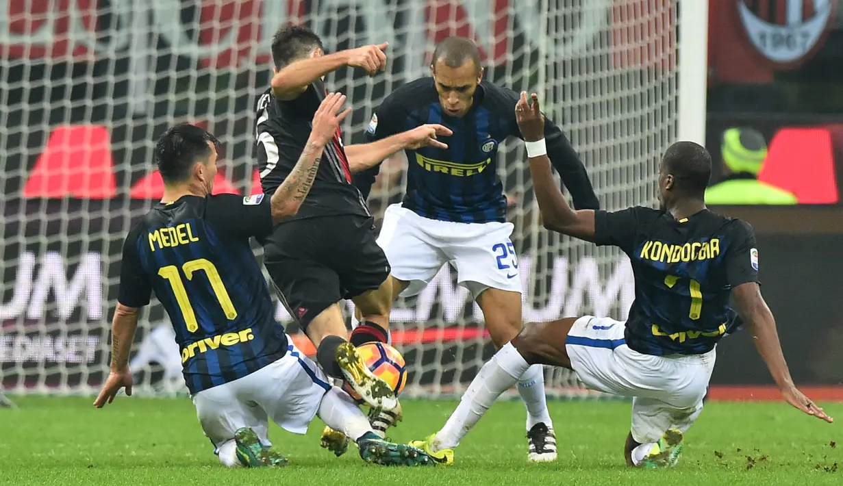 Gelandang AC Milan, Giacomo Bonaventura (tengah) berusaha melewati tiga pemain Inter Milan pada laga Liga Italia Serie A di Stadion San Siro, Milan, (20/11). AC Milan bermain imbang dengan Inter Milan dengan skor 2-2. (AFP PHOTO/Guiseppe Cacace)