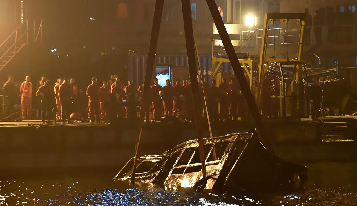 Sebuah crane mengevakuasi bus setelah jatuh dari jembatan ke Sungai Yangtze di Chongqing barat daya China (1/11). Bus berisikan 15 orang jatuh ke Sungai Yangtze, China pada Minggu (28/10). (AFP Photo/Str)