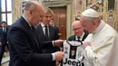 CEO Juventus Giuseppe Marotta dan Wakil ketua Juventus Pavel Nedved menyerahkan jersey Juventus kepada Paus Fransiskus di Vatikan, Roma, Italia (16/5). Audiensi digelar jelang final Coppa Italia antara Juventus dan Lazio. (AFP Photo/Osservatore Romano)