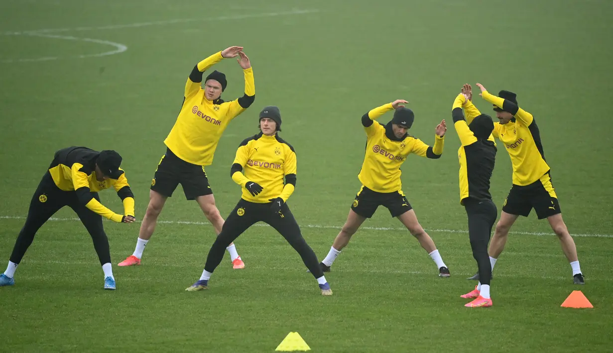 Para pemain Borrusia Dortmund melakukan pemanasan selama sesi latihan di tempat latihan tim di Dortmund, Jerman barat (9/3/2021). Dortmund sebelumnya berhasil mengalahkan Sevilla dengan skor 3-2 di leg pertama. (AFP/Ina Fassbender)