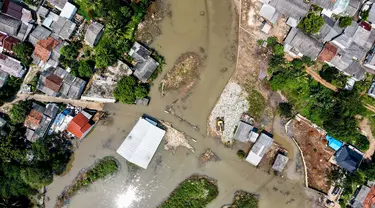 Foto udara menunjukkan pemandangan rumah-rumah penduduk dan jalan yang terendam air akibat luapan sungai sebagai dampak longsornya tumpukan sampah yang menyumbat aliran sungai di Depok pada 7 Mei 2024. (BAY ISMOYO/AFP)