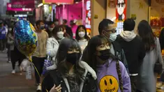 Orang-orang memakai masker untuk melindungi diri dari penyebaran virus corona, berjalan di jalan di Hong Kong (14/1/2022). Hong Kong akan menangguhkan penerbangan transit dari sekitar 150 negara dan wilayah yang dianggap berisiko tinggi karena virus corona selama sebulan penuh. (AP Photo/Kin Cheung)