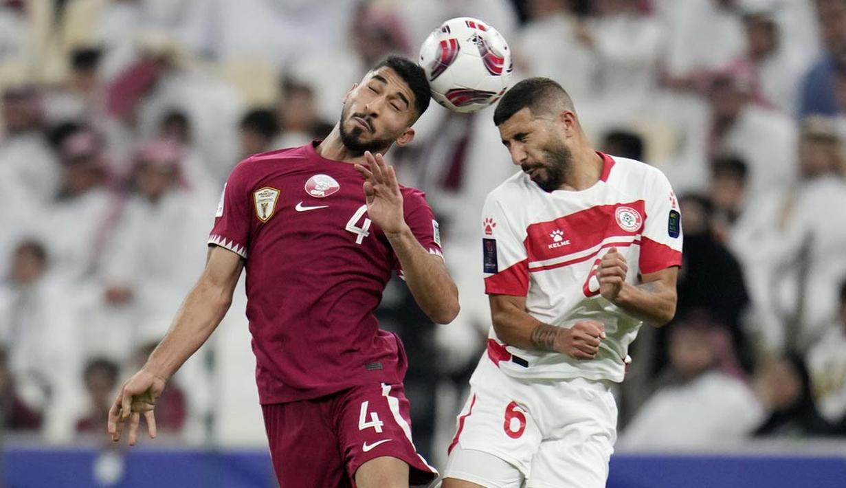 Pemain Qatar, Mohammed Waad Albayati, duel udara dengan pemain Lebanon, Hussein Zein, pada babak penyisihan Grup A Piala Asia 2023 di Stadion Lusail, Jumat (12/1/2024). Tuan rumah tampil agresif menekan sang tamu di sepanjang laga. (AP Photo/Aijaz Rahi)