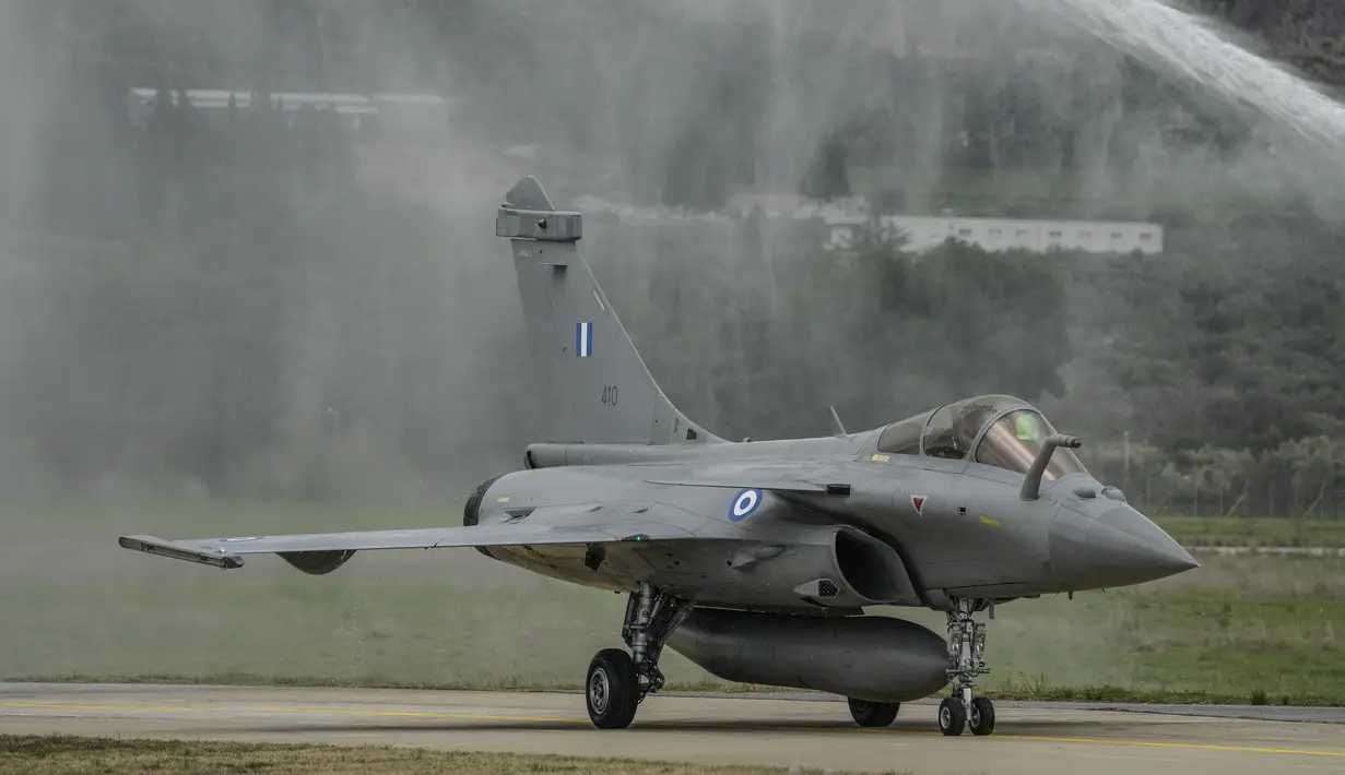 Sebuah jet Rafale disemprot dengan air saat angkatan udara Yunani memberi hormat kepada enam jet baru di pangkalan udara militer Tanagra, utara Athena, Yunani (19/1/2022). Rafale ini semakin memicu ketegangan dengan saingan bersejarah Yunani dan mitra NATO Turki. (AP Photo/Thanassis Stavrakis)