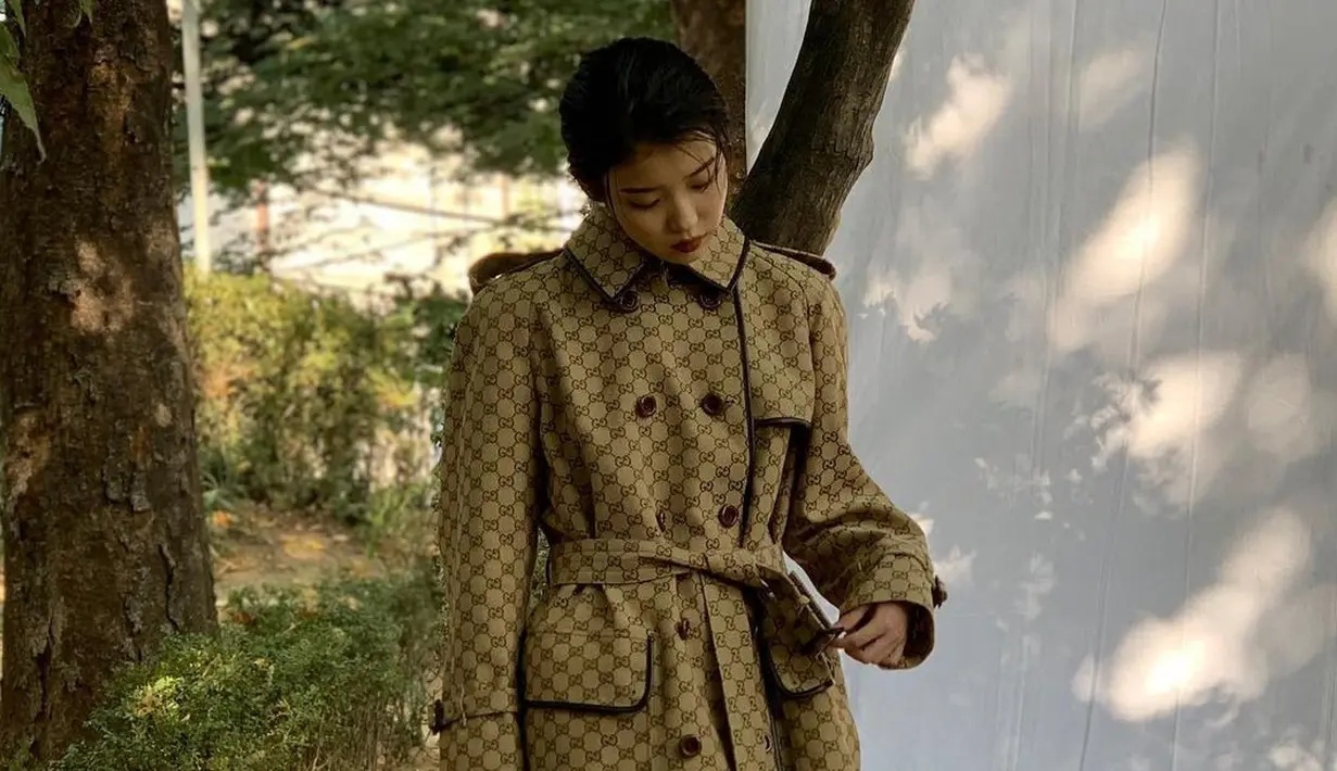 Untuk pemotretan sebuah majalah, IU tampil mengenakan one piece coat dari Gucci dengan detail belt untuk membuat tampilan tubuh yang lebih ramping. Foto: Instagram.