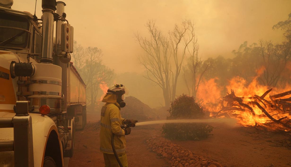 Seorang petugas pemadam kebakaran memadamkan kobaran api di dekat Wooroloo, di Perth, Australia, Selasa (2/1/2021). Kebakaran hutan tak terkendali di sebuah wilayah di sebelah timur laut Perth telah menghancurkan puluhan rumah dan kemungkinan mengancam lebih banyak lagi. (Evan Collis/DFES via AP)