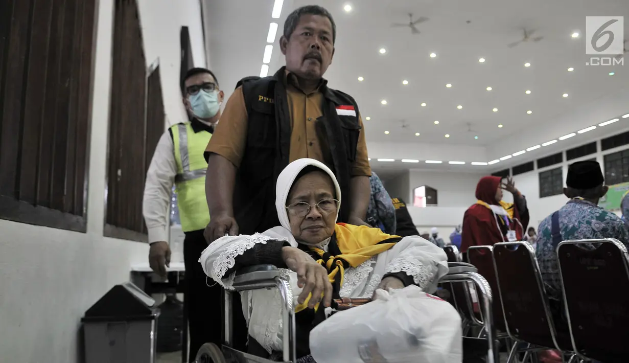 PPIH membantu salah seorang jemaah haji lansia dengan kursi roda saat tiba di Asrama Haji Pondok Gede, Jakarta, Rabu (29/8). (Merdeka.com/Iqbal S. Nugroho)
