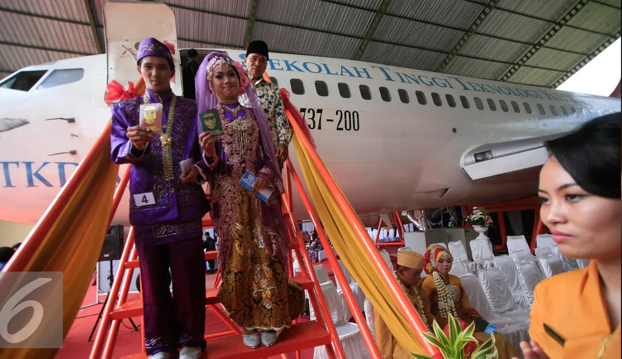 Sepasang mempelai menuruni anak tangga peasawat usai menjalani prosesi nikah massal di kampus STTKD, Yogyakarta, Senin (4/4/2016). Sebanyak 21 pasangan pengantin mengikuti nikah bareng angkasa di atas pesawat boing. (Liputan6.com/Boy Harjanto)