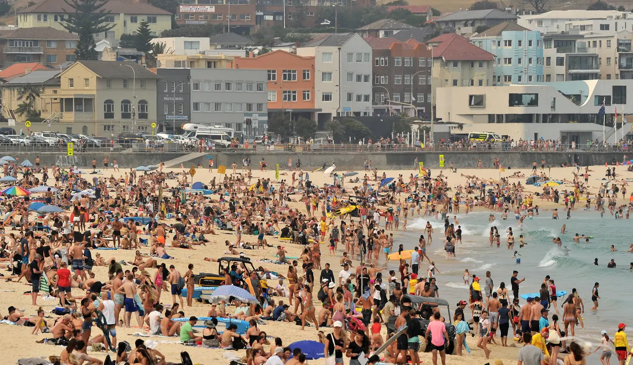 Pengunjung berjemur di pantai Bondi ketika pantai Bondi ketika suhu udara melonjak di Sydney (21/12/2019). Australia pekan ini mengalami rekor hari terpanasnya yang tercatat dalam sejarah dan gelombang panas diperkirakan akan terus meningkat. (AFP/Farooq Khan)