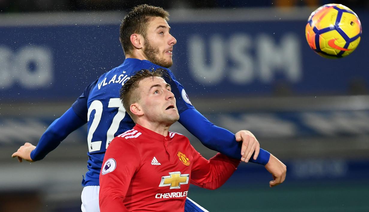 Pemain Everton, Nikola Vlasic (kiri) melakukan duel dengan pemain Manchester United, Luke Shaw pada lanjutan Premier League di Goodison Park, Liverpool, (1/1/2018). MU menang 2-0. (AFP/Paul Ellis)