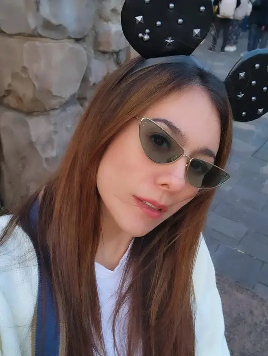 Liburan dengan tampilan yang chic. Wulan Guritno menampilkan paras rupawannya di tempat terbuka, mengenakan sunglasses dan bando mickey mouse, mempermanis penampilannya secara keseluruhan. Foto: Instagram.