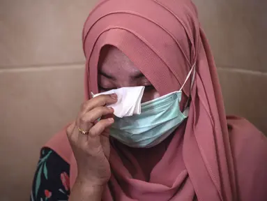 Berda Asmara menghapus air mata saat berbicara tentang suaminya Serda Mes Guntur Ari Prasetyo di rumah mereka di Surabaya, Jumat (23/4/2021). Serda Mes Guntur Ari Prasetya merupakan juru diesel di kapal selam KRI Nanggala-402 yang hilang kontak. (Juni Kriswanto/AFP)