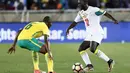 Bek Senegal, Youssouf Sabaly, berusaha melewati gelandang Afrika Selatan, Thamsanqa Mkhize, pada laga kualifikasi Piala Dunia 2018 di Stadion The Peter Mokaba, Jumat (10/11/2017). Senegal menang 2-0 atas Afrika Selatan. (AFP/Phill Magakoe)