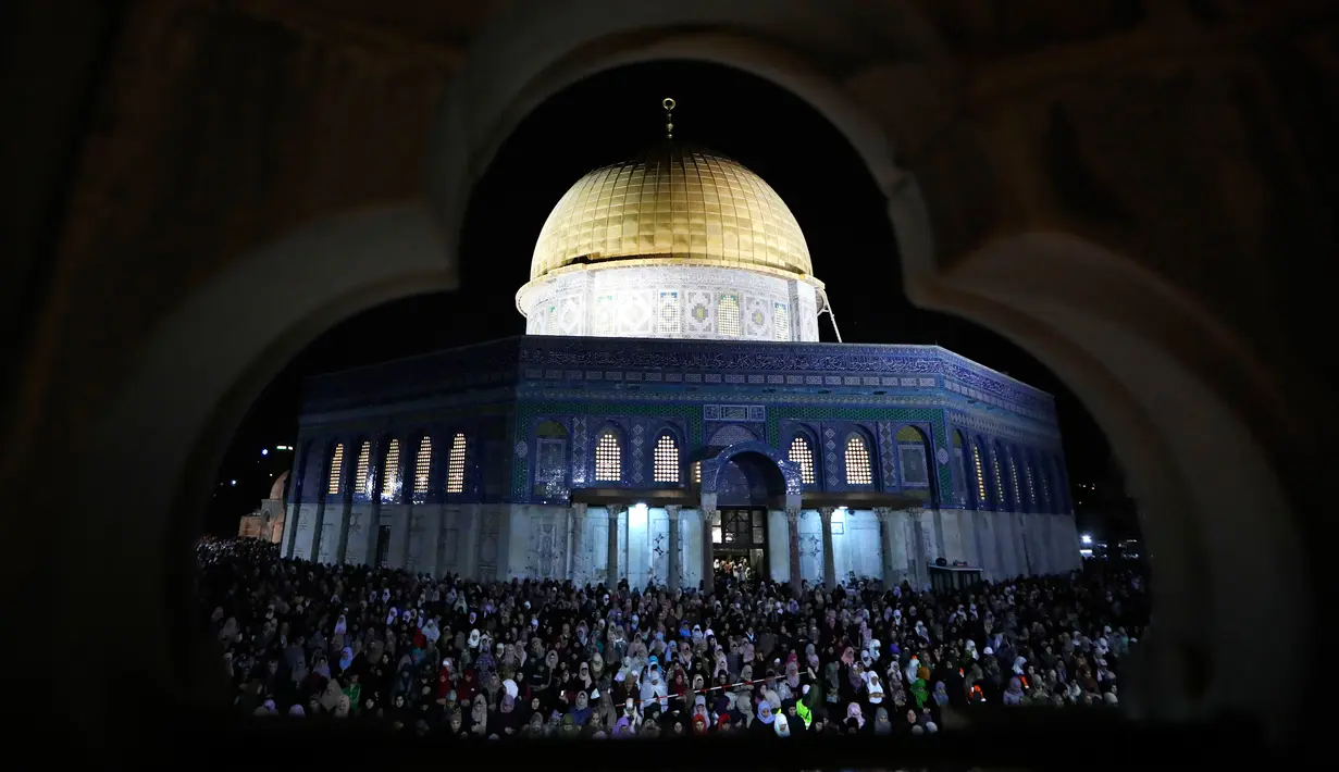 Muslim Palestina memanjatkan doa sambil menunggu Lailatul Qadar di luar Dome of the Rock, kompleks masjid Al-Aqsa di Kota Tua Yerusalem, Senin (11/6). Malam ganjil menjadi prioritas muslim beriktikaf untuk mendapat Lailatul Qadar. (AFP/AHMAD GHARABLI)
