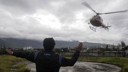 Petugas mengarahkan helikopter yang membawa korban tewas setibanya di sebuah rumah sakit di Ibu Kota Nepal, Kathmandu, Senin (8/8). Tujuh orang, termasuk bayi dan pilot tewas akibat jatuhnya Helikopter Fishtail Air. (AFP PHOTO/BIKASH Karki)