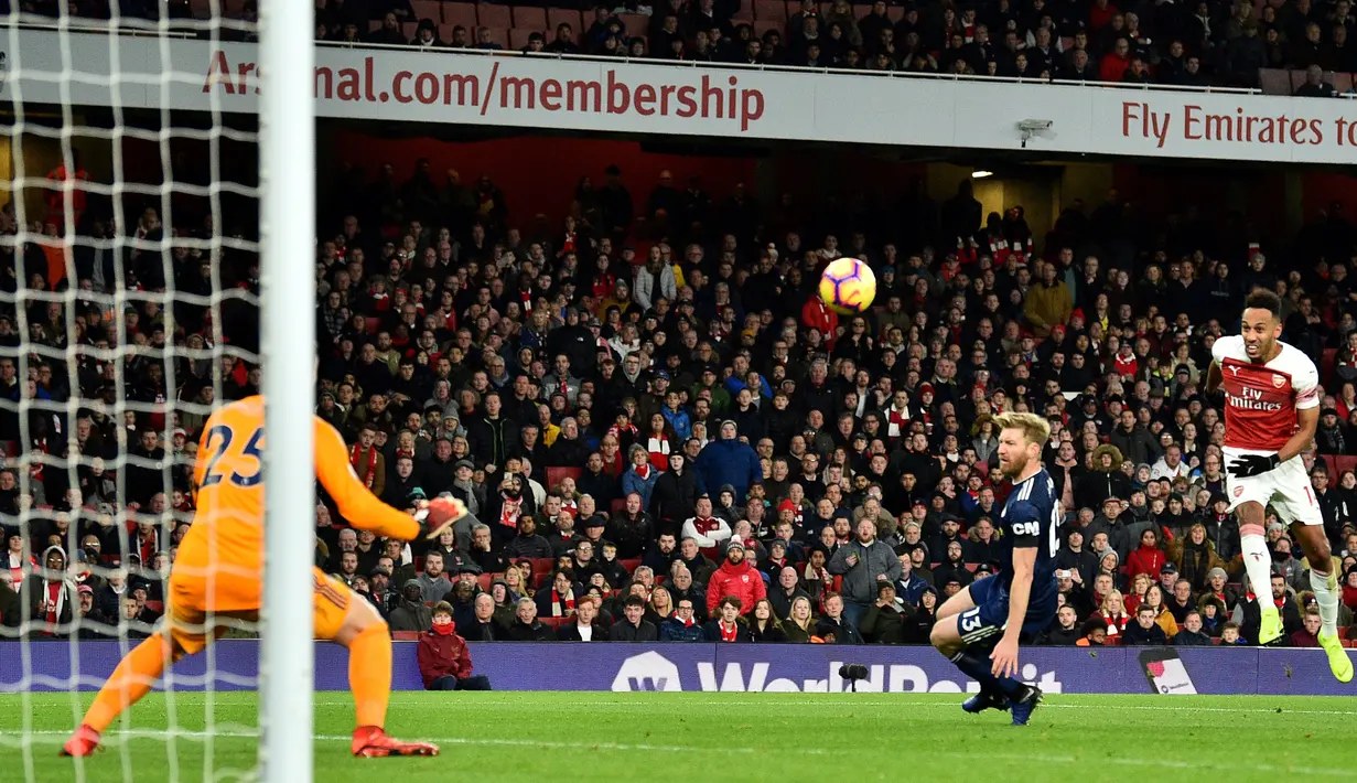 Striker Arsenal, Pierre-Emerick Aubameyang, melepaskan tendangan saat melawan Fulham pada laga Premier League di Stadion Emirates, London, Selasa (1/1). Arsenal menang 5-1 atas Fulham. (AFP/Glyn Kirk)
