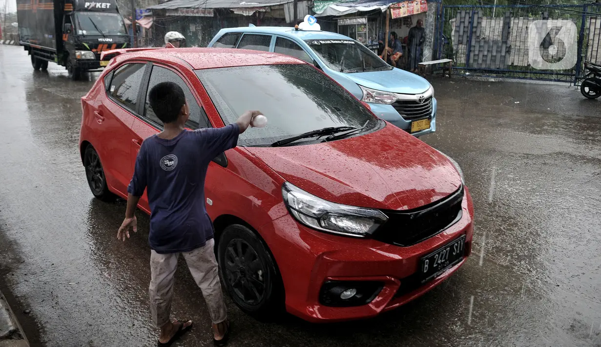 Sejumlah anak menawarkan jasa membersihkan kaca mobil di Jalan Raya Bekasi, Cakung, Jakarta, Selasa (17/3/2020). Akibat keterbatasan ekonomi, anak-anak yang masih duduk di bangku sekolah dasar ini nekat menawarkan jasa membersihkan kaca mobil dan truk di jalan raya. (merdeka.com/Iqbal S Nugroho)
