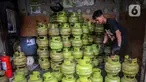Pekerja menata tabung liquefied petroleum gas (LPG) 3 Kg di sebuah agen di kawasan Jakarta, Rabu (27/12/2023). Pemerintah mendorong penyaluran LPG 3 Kg lebih tepat sasaran dengan menggunakan Kartu Tanda Penduduk (KTP) mulai 1 Januari 2024. (Liputan6.com/Angga Yuniar)