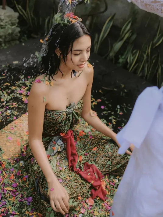 Aurelie Moeremans memperlihatkan dirinya melukat dalam beberapa foto. Di foto pertama, ia terlihat duduk bersila mengenakan kain Bali bernuansa kehijauan, sebagai kemben. Foto: Instagram.