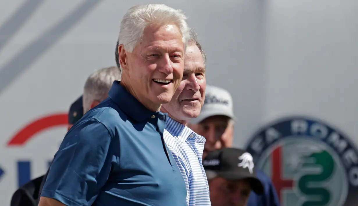 Mantan Presiden AS, Bill Clinton dan George Bush pada upacara pembukaan pertandingan golf President Cup di New Jersey, Kamis (28/9). Selain George W Bush dan Bill Clinton, turnamen juga dihadiri mantan Presiden AS, Barack Obama. (AP/Julio Cortez)