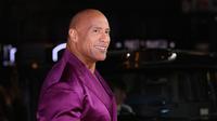Dwayne Johnson berpose untuk fotografer saat tiba pada pemutaran perdana film 'Black Adam' di London, Inggris, 18 Oktober 2022. Melengkapi penampilannya, Dwayne Johnson memakai kalung perak yang melingkar di leher lencangnya. (Photo by Vianney Le Caer/Invision/AP)