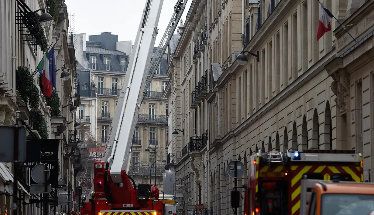 Petugas pemadam berusaha memadamkan api yang membakar lantai atas Hotel Ritz, Paris, Selasa (19/1). Enam puluh petugas pemadam kebakaran dan 15 mobil pemadam kebakaran dikerahkan untuk memadamkan api.  (AFP PHOTO/Lionel Bonaventure)